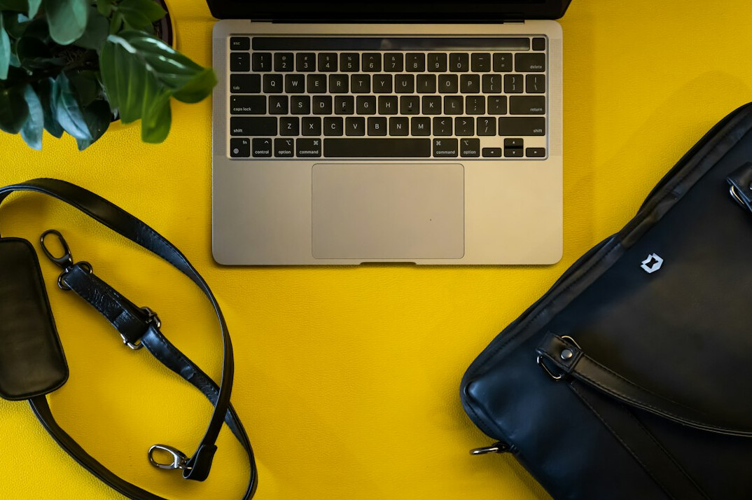 Flat lay of a laptop, notebook, and documents on a desk
